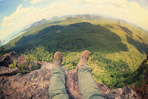 young woman hiker legs sit on beautiful mountain peak enjoy the view
