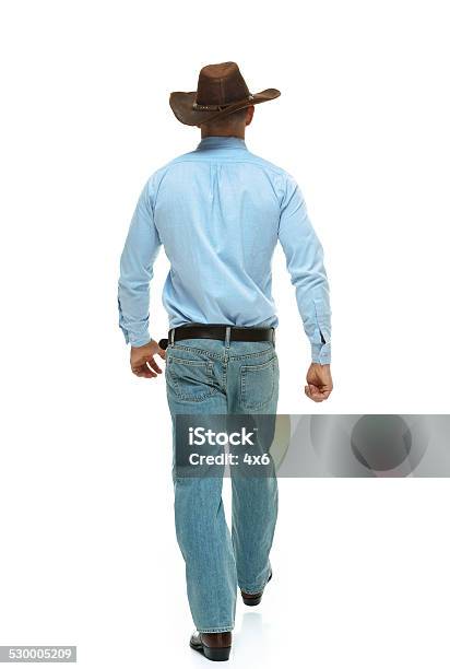 Rear View Of Cowboy Waking Stock Photo - Download Image Now - Rear View, Cowboy, Men
