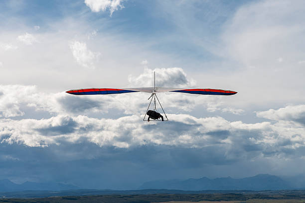istock Hang glider soars high above clouds,mountains 530005381