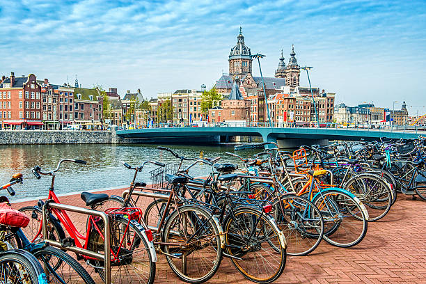 Bicycle parking next to Amsterdam City Center Row of Bicycles parked next to Amsterdam City Center (Centrum). Visible are typical Church and Dutch Houses in the background. Amsterdam, The Netherlands.  bicycle rack photos stock pictures, royalty-free photos & images