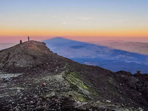 Picture taken from the summit of mount Etna (3300 m high), during the sunset; the big shadow of the volcano is clearly visible as a triangle.