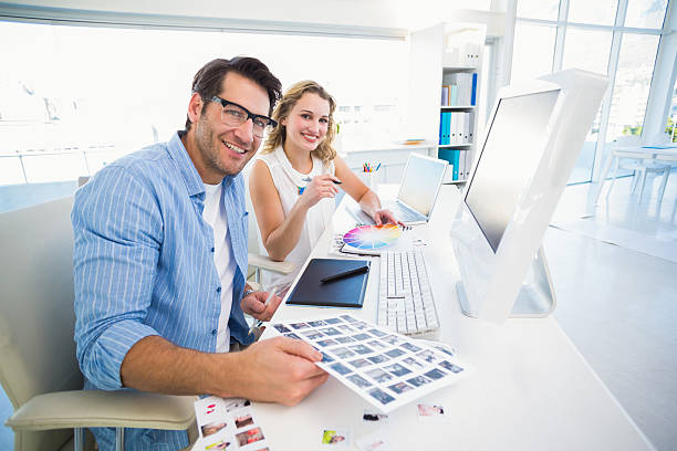 istock Two happy photo editors working with contact sheets 530006287