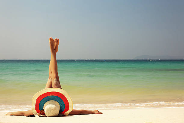 istock Young woman with long legs wearing big hat on beach 530007010