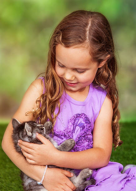 istock Girl and Kitten Sitting on Grass 530008468