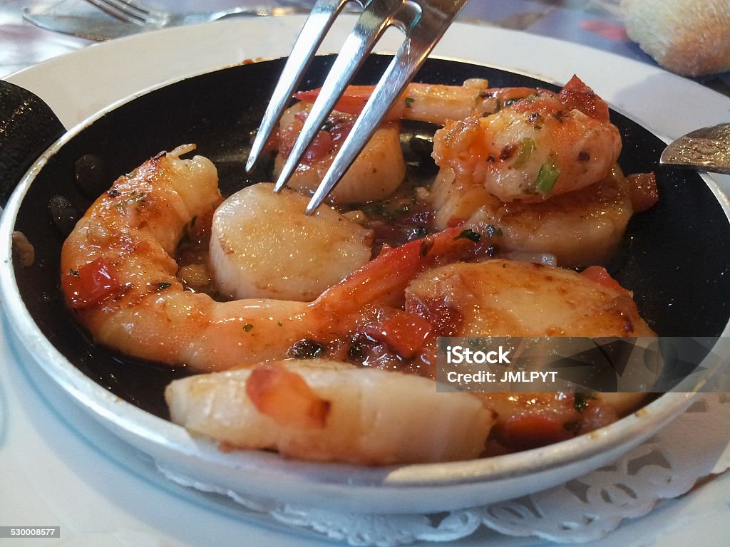 Saute of scallops and prawns Eating saute of scallops (coquille saint-jacques) and prawns in a french restaurant Appetizer Stock Photo