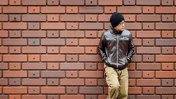 istock Asian Man in a Brown Jacket Leans Against the Wall 530008962