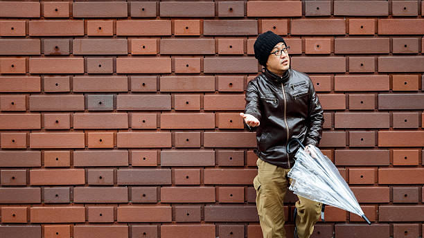 istock Asian Man in a Brown Jacket Leans Against the Wall 530009018
