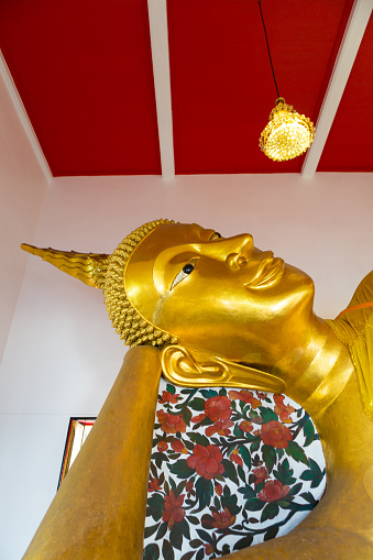 Bangkok, Thailand - January 14, 2016: Huge golden Buddha with white and red background inside a Thai temple, Bangkok, Thailand. Low angle view.