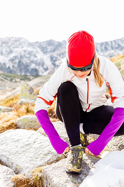 istock Runner tying sport shoe in mountains on trail 530044231