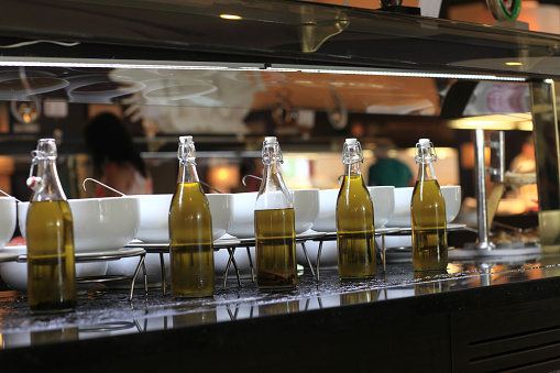 Bottles with different types of olive oil at a buffet
