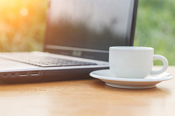istock Cup of coffee and laptop on the table 530050317