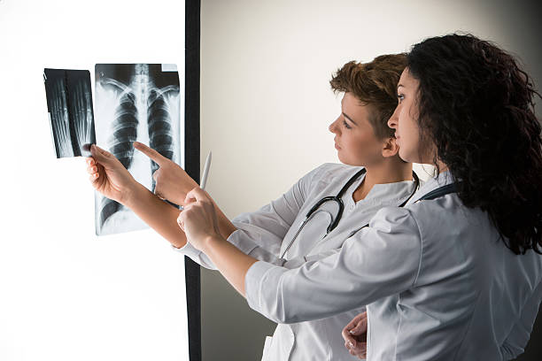 istock Two attractive young doctors looking at x-ray results 530050679