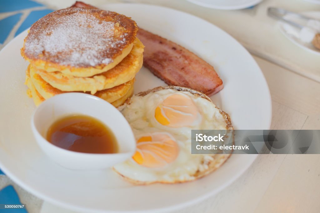 Breakfast time Pancakes served with eggs, bacon and maple syrup. American Culture Stock Photo