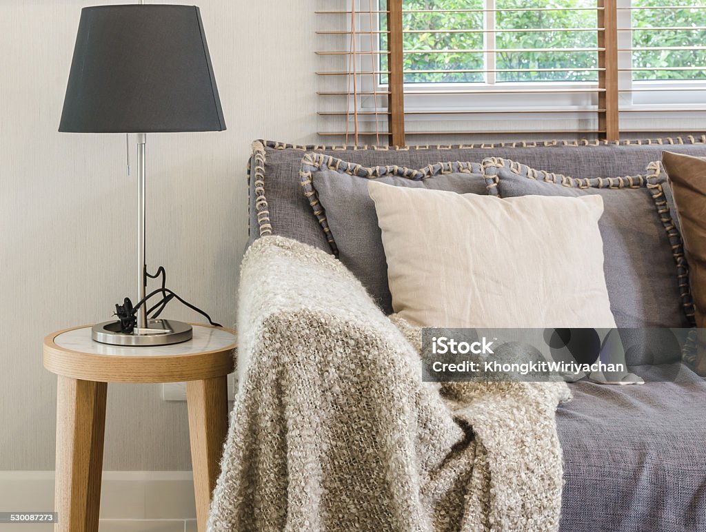 brown blanket on sofa with lamp in living room brown blanket on sofa with lamp in living room at home Apartment Stock Photo