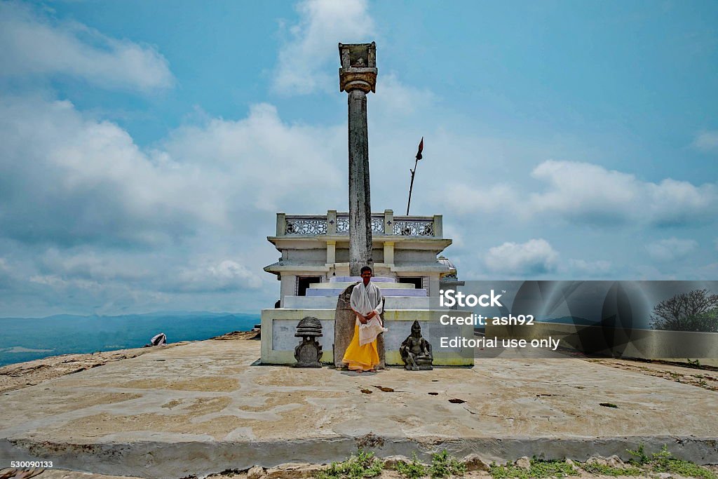 Monk standing on among the oldest temple in India Kundadri Hill,Agumbe,Karnataka,India - May 7,2014 : A monk standing on a site of Hindu Temple located in Kundadri Hill,India.The temple age is around 1000 years old. Adult Stock Photo
