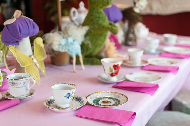 Table ready for a children's birthday fairy tea party, decorated with cute and enchanting tea sets and accessories.