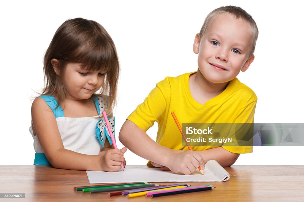 Children draws at the desk Little boy and little girl draws at the desk Blond Hair Stock Photo