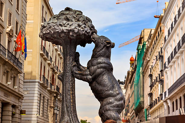 Madrid, Spain - May 8, 2014: Bear and Mulberry Tree El Oso y El Madrono Statue Symbol of Madrid Puerta del Sol Gate of the Sun Most Famous Square Building Cranes in Madrid Spain Statue created in 1967 by sculptor Antonio Navarro Santa Fe