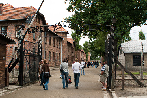 Auschwitz, Poland - August 13, 2006: Main entrance with barrier to the Auschwitz concentration camp.It was the biggest Nazi camp located near Krakow at the town of Oswiecim/Auschwitz/.Many jewish people and political prisoners were tortured to death,dying from starvation and exhaustion.Nowadays the camp is functioning as a museum for the tourists.
