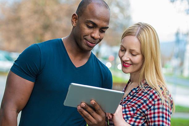 istock Friends Looking at Digital Tablet Outdoors 530102669