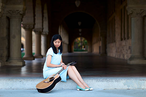 istock Asian girl with Accoustic Guitar 530103349