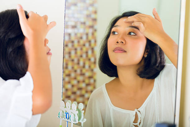 istock Asian woman discovering a pimple in face 530115939