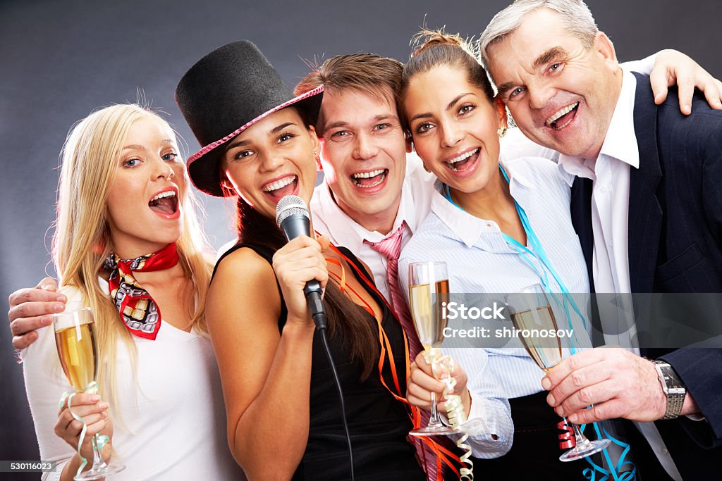 Performing songs Photo of businesspeople with flutes of champagne singing at Christmas party Champagne Stock Photo