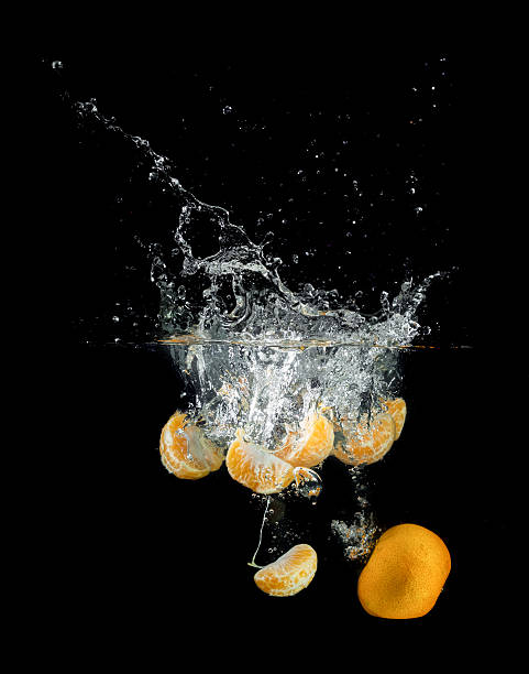 istock Fresh orange falling and splashing into water. 530118387