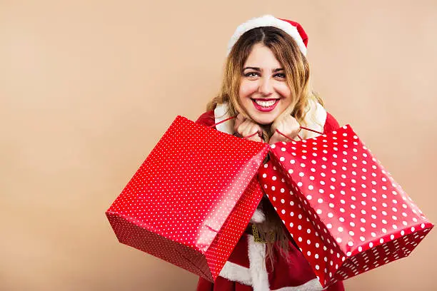 Happy Mrs.Claus holding shopping bags and smiling