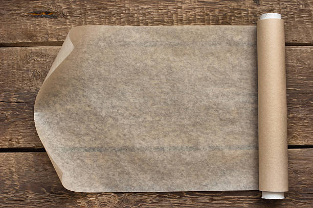 istock Open roll of paper on the wooden table background 530119371