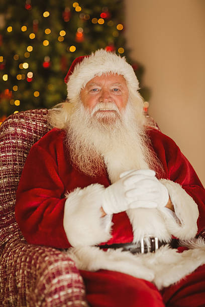 istock Happy santa relaxing on the armchair 530120473