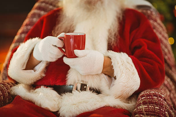 istock Mid section of santa holding hot drink 530120489