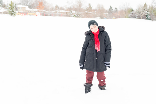 Latin senior lady having fun,enjoying,laying down and having her picture taken in her first snow of her life at age 74