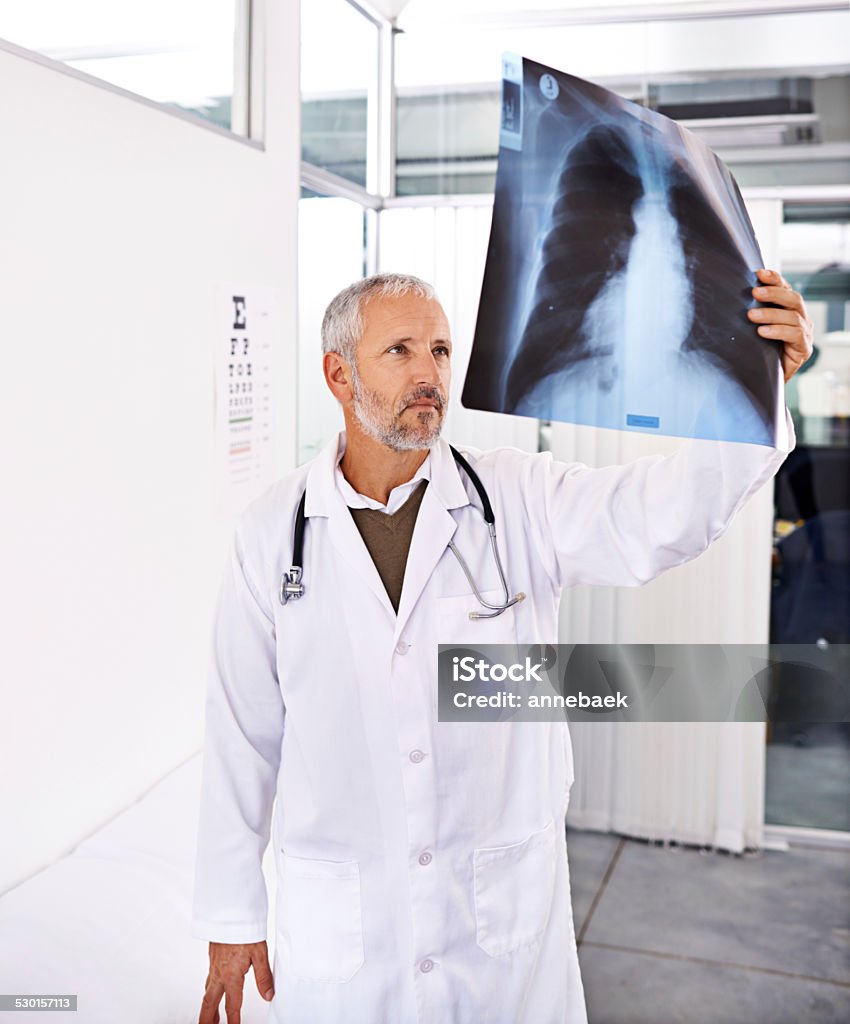 They want his expert opinion Shot of a mature male doctor examining an x-ray image at a hospitalhttp://195.154.178.81/DATA/istock_collage/0/shoots/784877.jpg 40-49 Years Stock Photo
