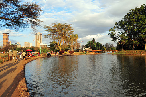 Nairobi, Kenya - August 25, 2008: people enjoy the late afternoon sun by the pond at Uhuru Park 