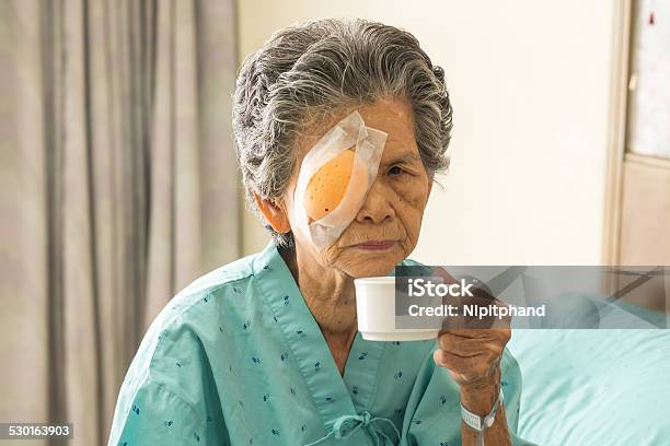Elder Female With Eye Patch Drinking Coffee After Cataract Surgery Stock Photo - Download Image Now