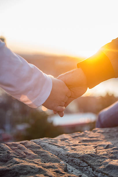 istock Unrecognizable romantic couple holding hands at sunset. 530181646