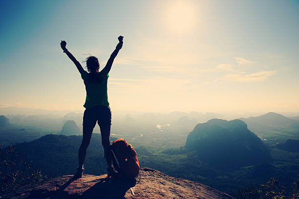 silhouette of cheering woman hiker open arms at mountain peak silhouette of cheering woman hiker open arms at mountain peak dedication stock pictures, royalty-free photos & images