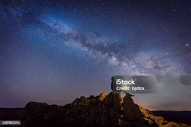 Man Sitting Under The Milky Way Galaxy Stock Photo - Download Image Now - Star - Space, Sky, Night