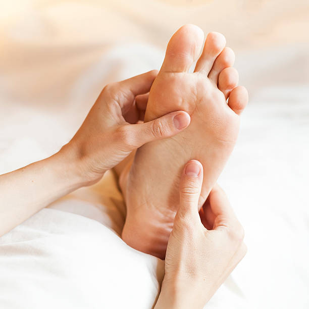 massage des pieds - human foot reflexology foot massage massaging photos et images de collection