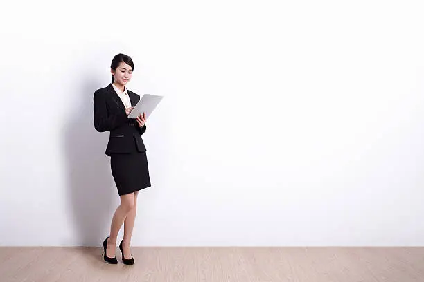 business woman using digital tablet pc with white wall background, great for your design or text, 