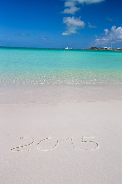 istock 2016 written on tropical beach white sand with xmas hat 530186855