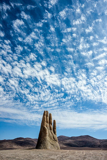 Sculpture Hand of Desert in the Atacama Desert Antofagasta, Chile – April 6, 2014: Rains in the Atacama Desert washed away graffiti from the sculpture Hand of Desert in the Atacama Desert atacama desert photos stock pictures, royalty-free photos & images