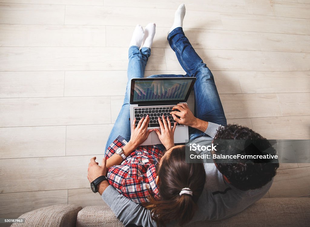 Online shopping. Young couple sitting on the floor and using laptop.Online shopping. Couple - Relationship Stock Photo