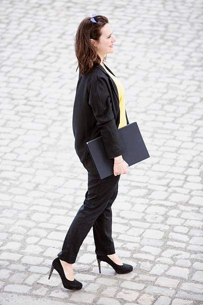 istock young woman walking and holding a book 530189324