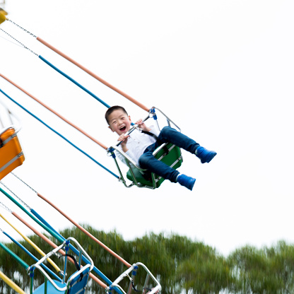 Little boy on a swinging ride