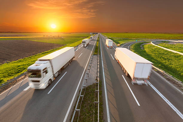 istock Delivery reefer transport trucks on the empty highway at sunset 530190784