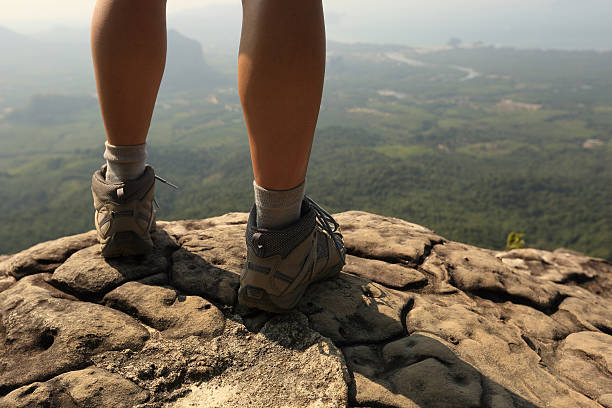 istock young woman hiker legs on mountain peak rock 530194052