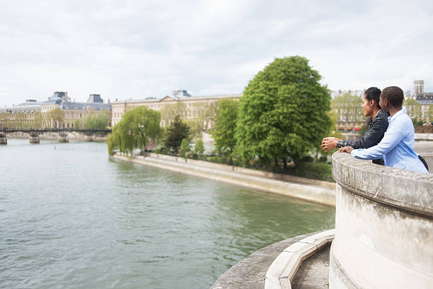 Women on the Pont Neuf bridge looking over the River Seine, Paris