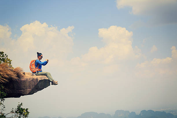 istock young asian woman hiker use smartphone at mountain peak 530197934